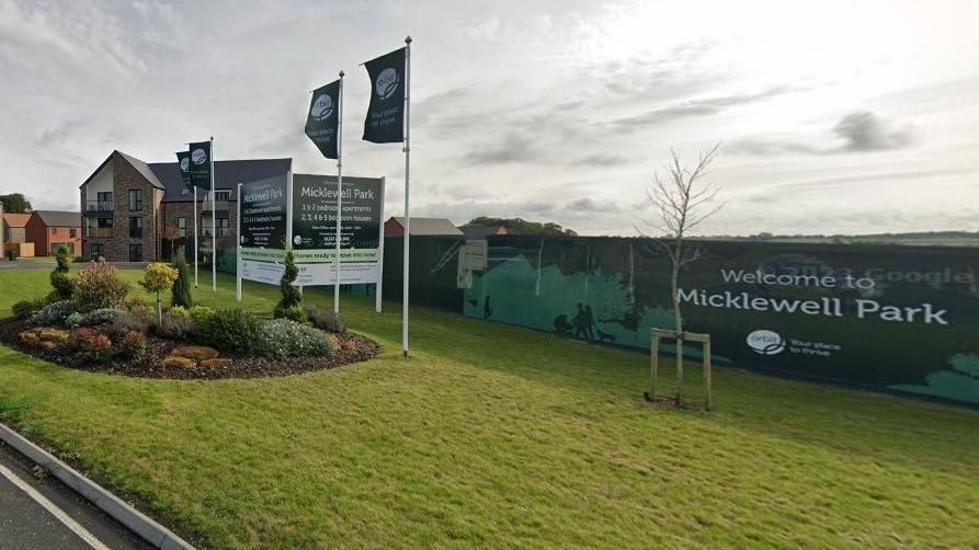 Entrance to new housing estate showing developer's signs and flags (Mickle Well estate, Daventry)