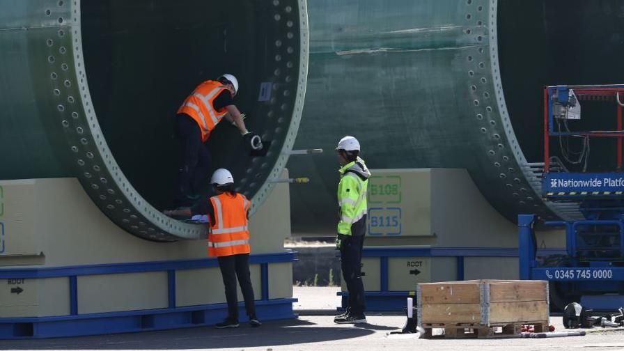 Workers inspect a wind turbine