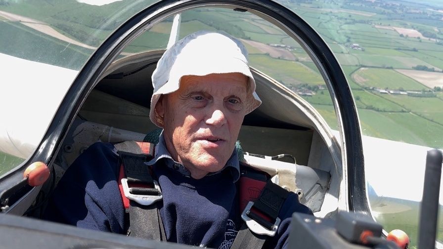 Club instructor, Steve Lambourne, sat in the cockpit of a glider with a patchwork of fields below him