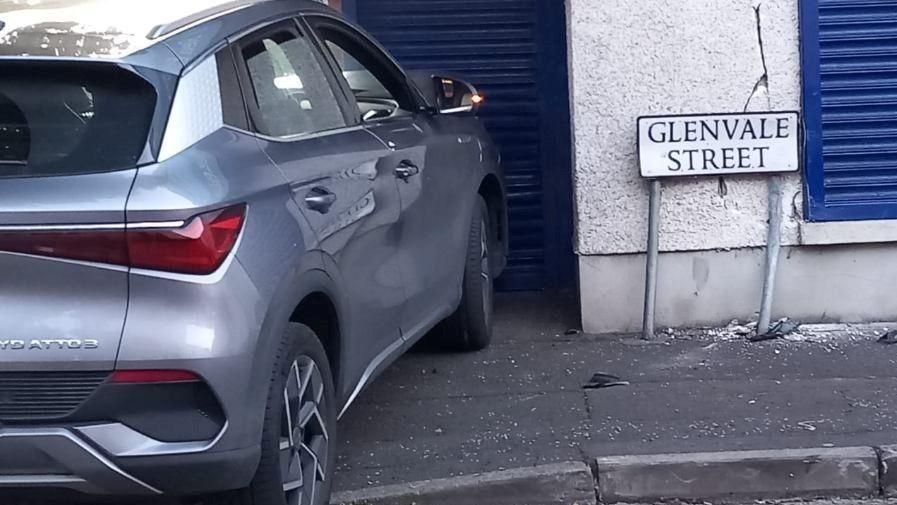 Grey car crashed into blue shutters