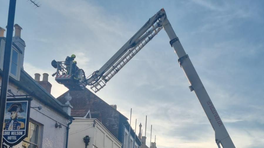 A cherry picker with firefighters on attending the fire on east street in Bridport