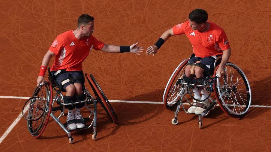 Alfie Hewett and Gordon Reid touch hands during their wheelchair tennis men's doubles final