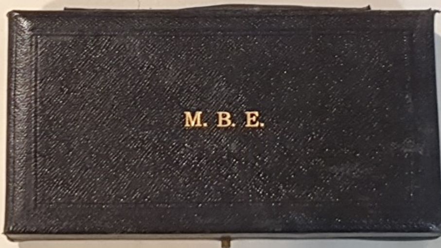 The outside of the MBE case is black and shiny with M B E written in gold