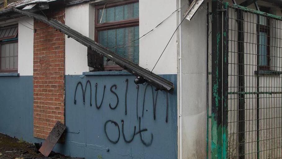 "Muslim out" graffiti on a white and blue wall