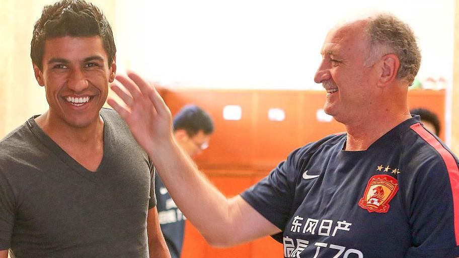 Luiz Felipe Scolari taps Paulinho on the face affectionately while wearing Guangzhou Evergrande training kit