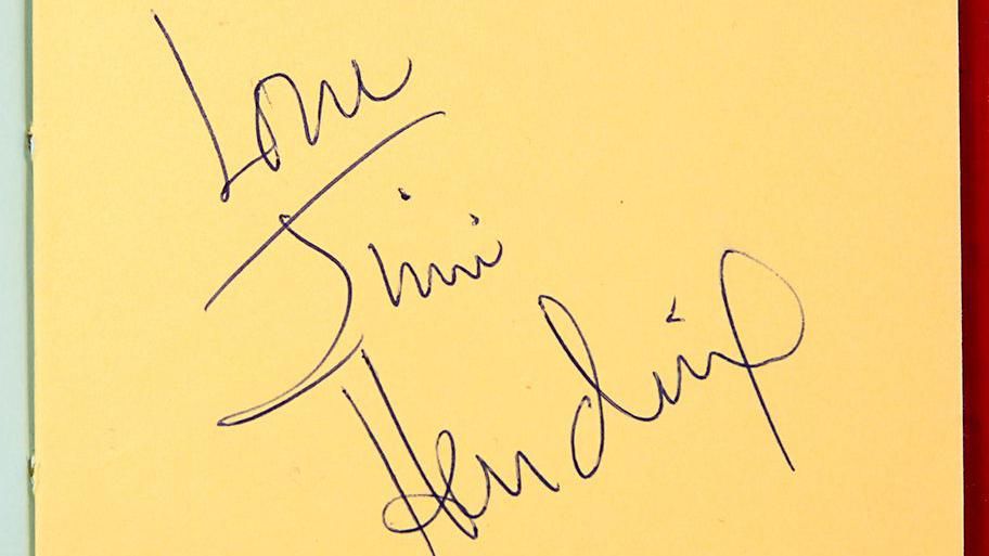 A message reading "Love, Jimi Hendrix" on a page in an autograph book