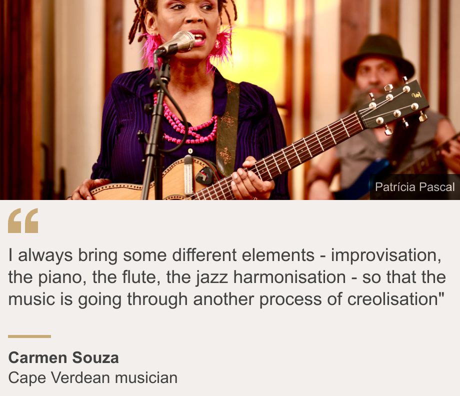 "I always bring some different elements - improvisation, the piano, the flute, the jazz harmonisation - so that the music is going through another process of creolisation"", Source: Carmen Souza, Source description: Cape Verdean musician, Image: Carmen Souza singing, holding a guiltar, another guitarist can be seen behind her