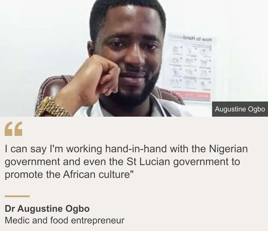 "I can say I'm working hand-in-hand with the Nigerian government and even the St Lucian government to promote the African culture"", Source: Dr Augustine Ogbo, Source description: Medic and food entrepreneur, Image: Augustine Ogbo smiles at the camera with his face rested on his hand. He wears a watch, a white doctor's jacket, and a stethoscope around his neck.