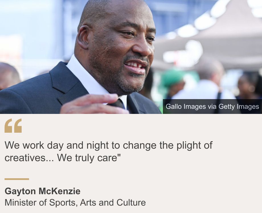 "We work day and night to change the plight of creatives... We truly care"", Source: Gayton McKenzie, Source description: Minister of Sports, Arts and Culture, Image: Gayton McKenzie wearing a suit holds his hand up as he is talking. He is looking to the right of the picture.