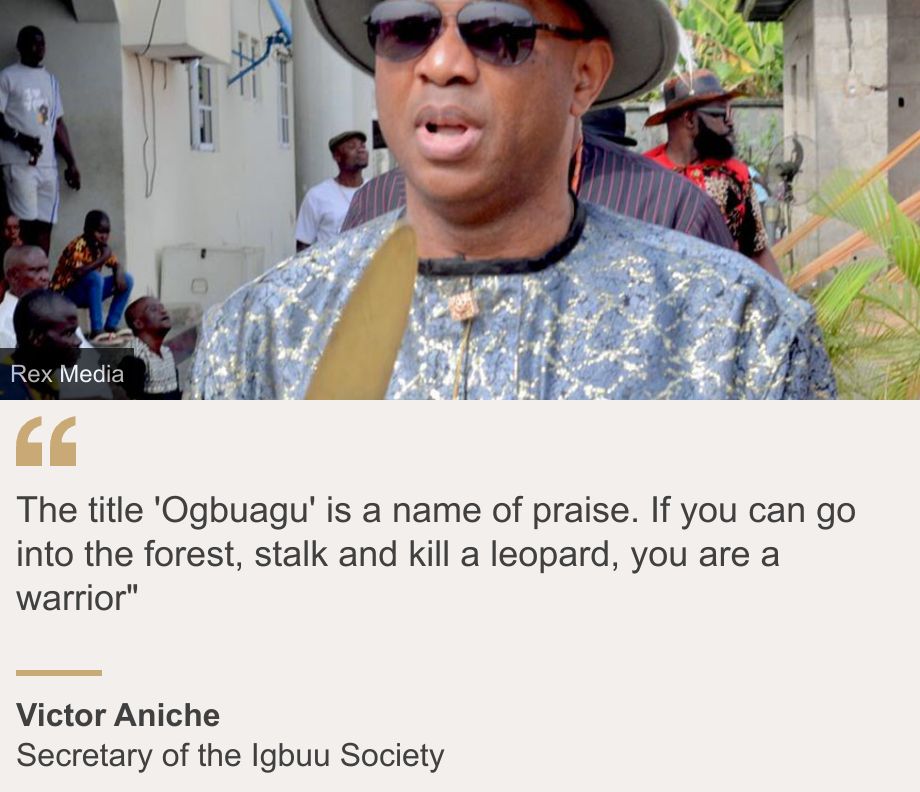 "The title 'Ogbuagu' is a name of praise. If you can go into the forest, stalk and kill a leopard, you are a warrior"", Source: Victor Aniche, Source description: Secretary of the Igbuu Society, Image: Victor Aniche in sunglasses wearing a grey head and patterned top and holding a gold sword