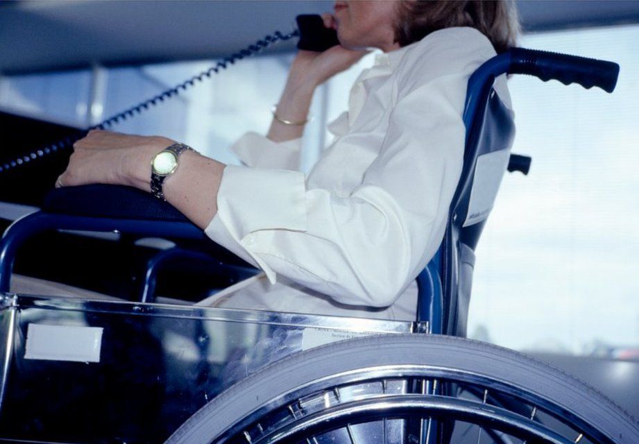 Woman in wheelchair uses landline