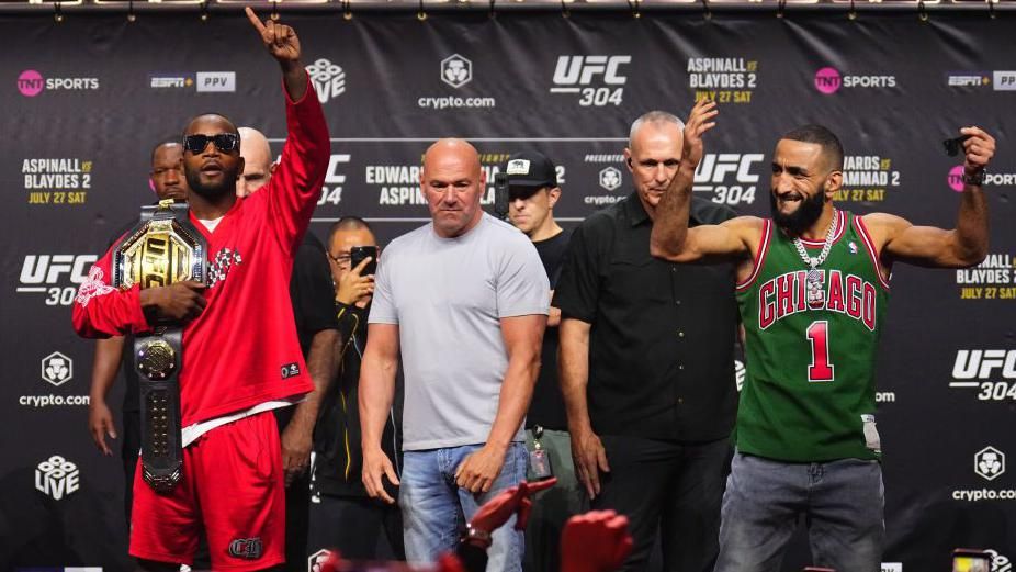 Leon Edwards in shades holding his UFC belt beside Belal Muhammad