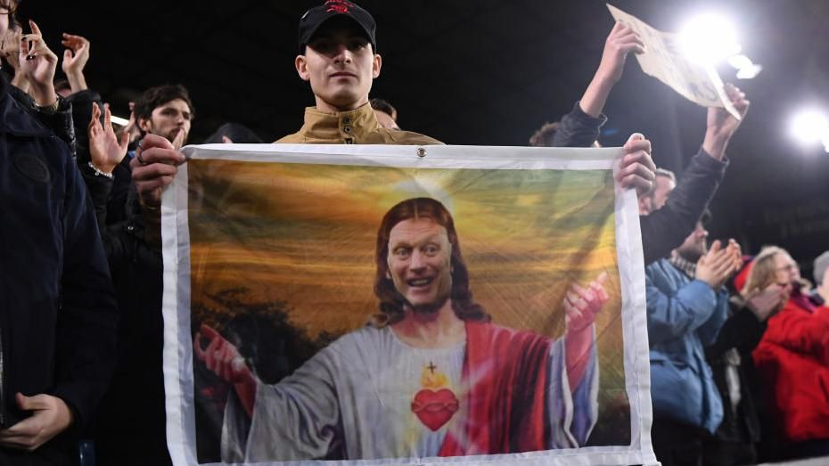 A fan holds an image of David Moyes' face on Jesus' body