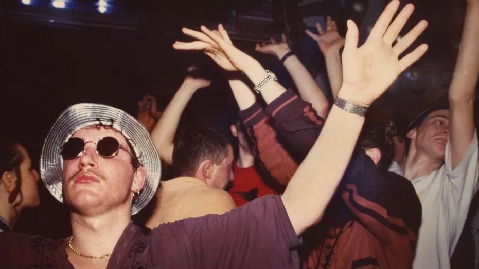 Men and women dancing inside The Eclipse nightclub, with one club-goer sporting a silver hat and sunglasses