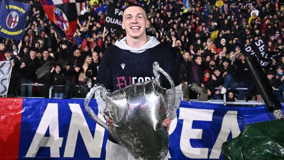 Bologna midfielder Lewis Ferguson with a Champions League trophy replica