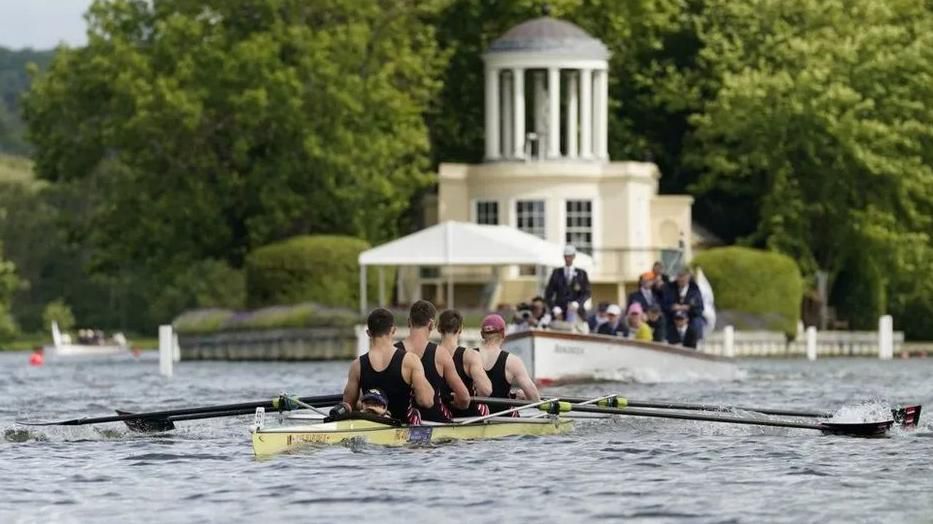 Four-man rowing crew, seen from behind, on the River Thames at the Henley Regatta