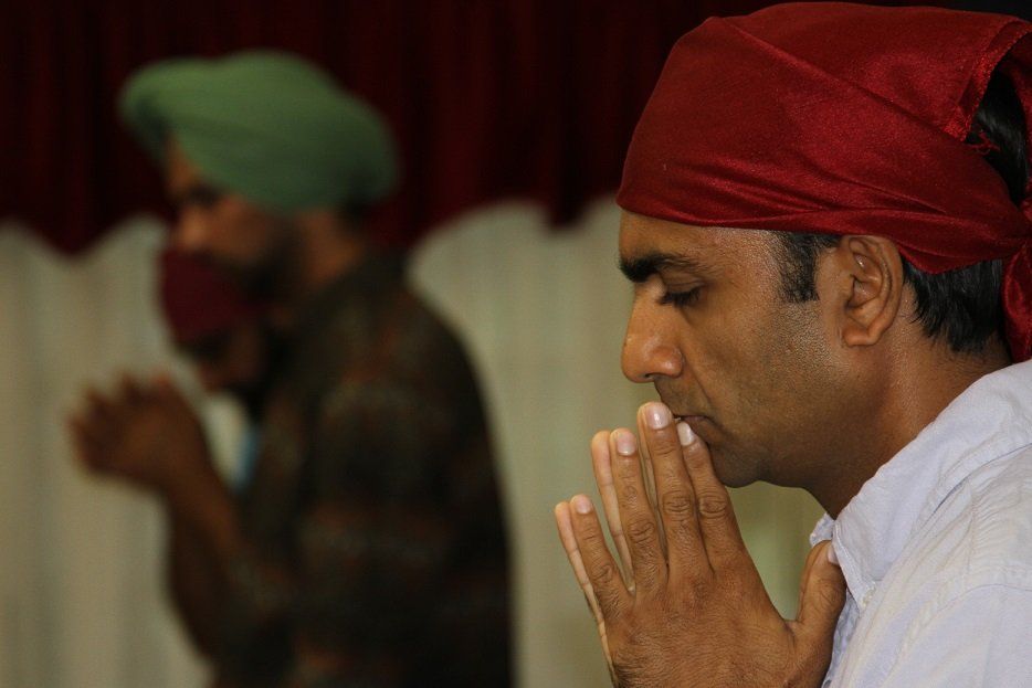 Sikh man without turban praying in the Tanpa gurdwara