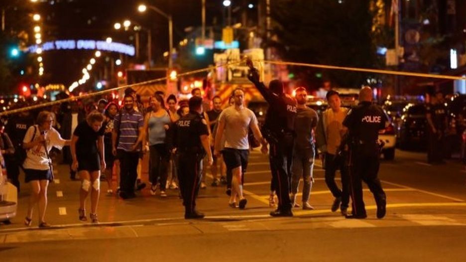 People leave an area sealed off by Canadian police after a mass shooting in Toronto. Photo: 22 July 2018