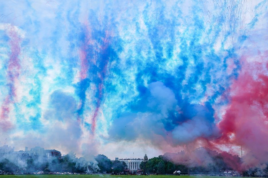 Trails of coloured smoke are seen in the air in front of the White House