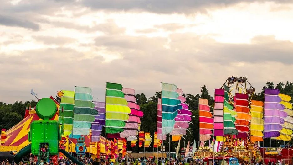 Colourful flags and banners billow in sunlight at Camp Bestival in Shropshire