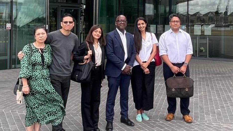 The Lau and Sajjad families pictured with Trevor Sterling outside City Hall