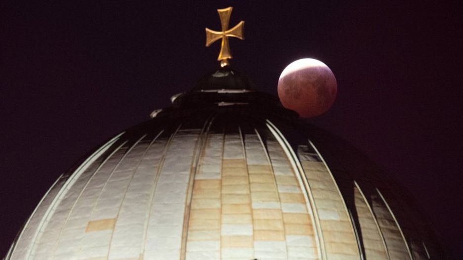 7 A view of the lunar eclipse over the cross on top of the Elizabeth Church in Nuremberg, Germany, 21 January 2019.