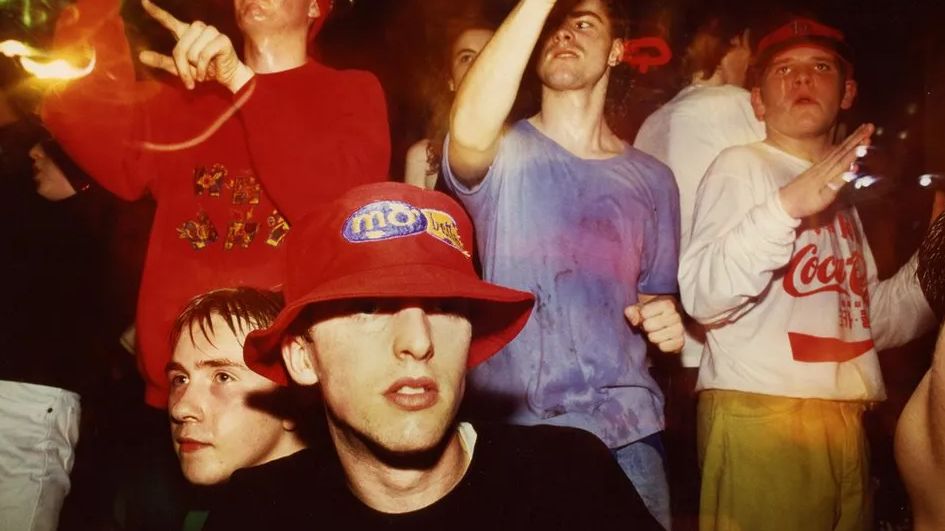 A group of ravers dancing at The Eclipse club in Coventry. They are wearing an array of bright clothes and a range of hats 