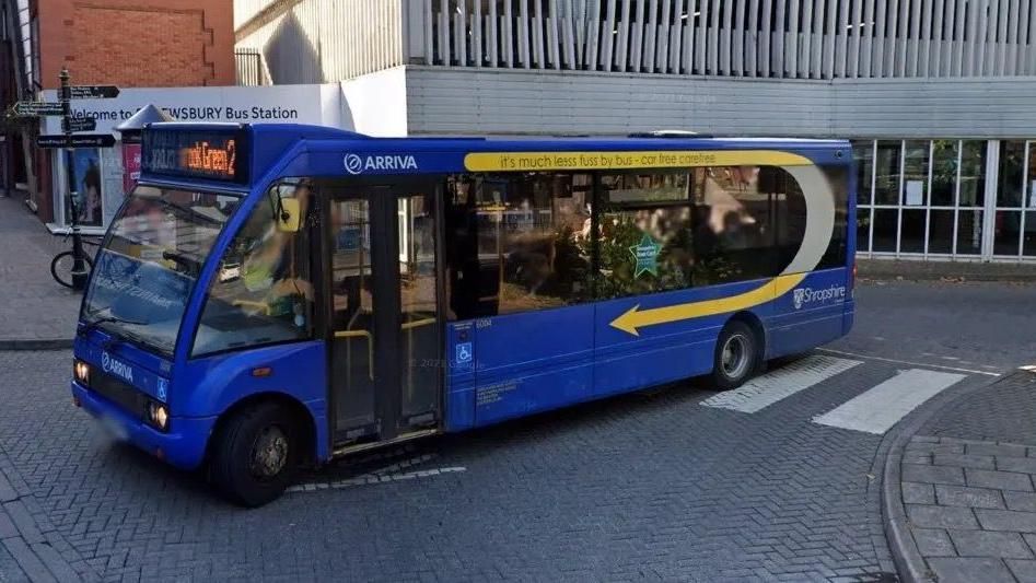 A blue bus parked on a road