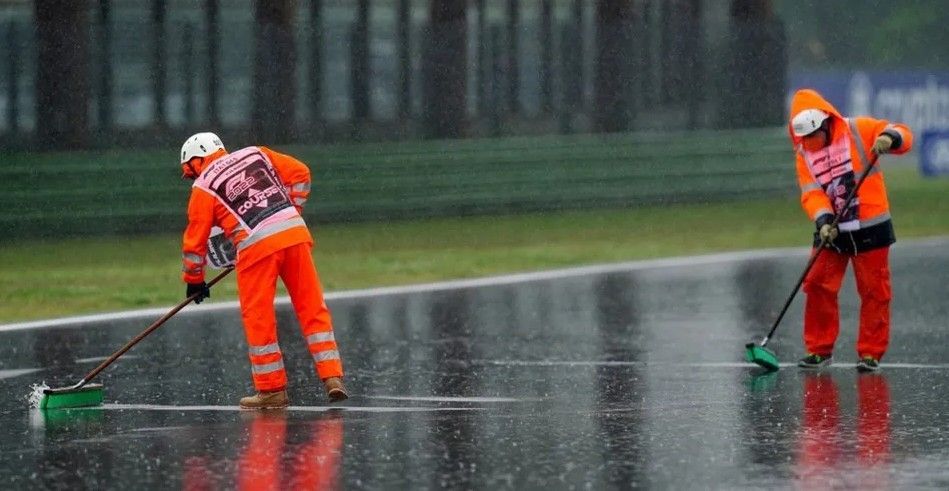Marshals clear water from the track at Imola in 2022 