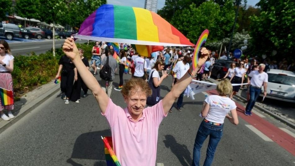 A man waves a flag at a gay pride event in Poland, 2019