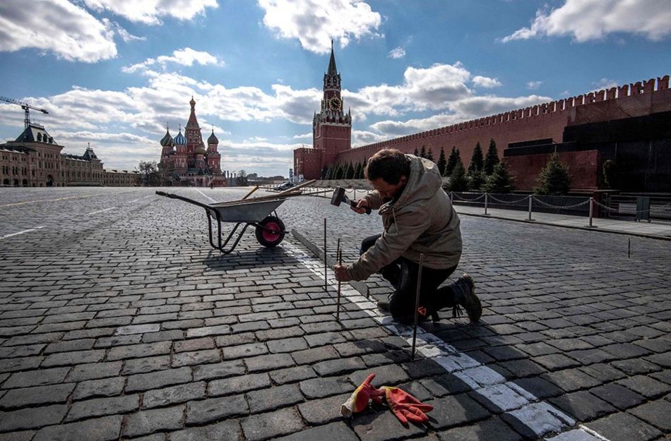 A man mends paving stones in Red Square