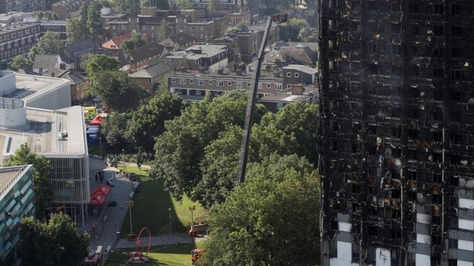 Burnt out tower block with water cannon on platform