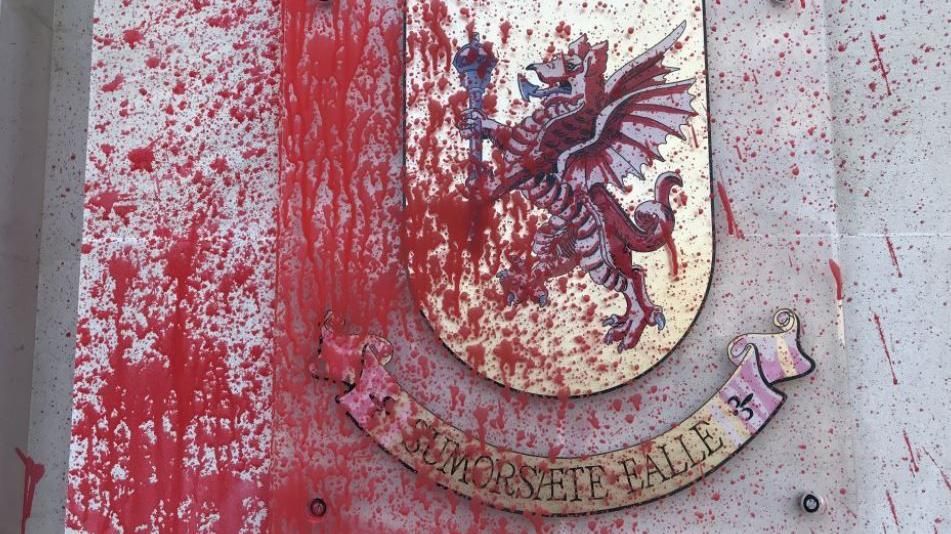 A coat of arms covered in red paint