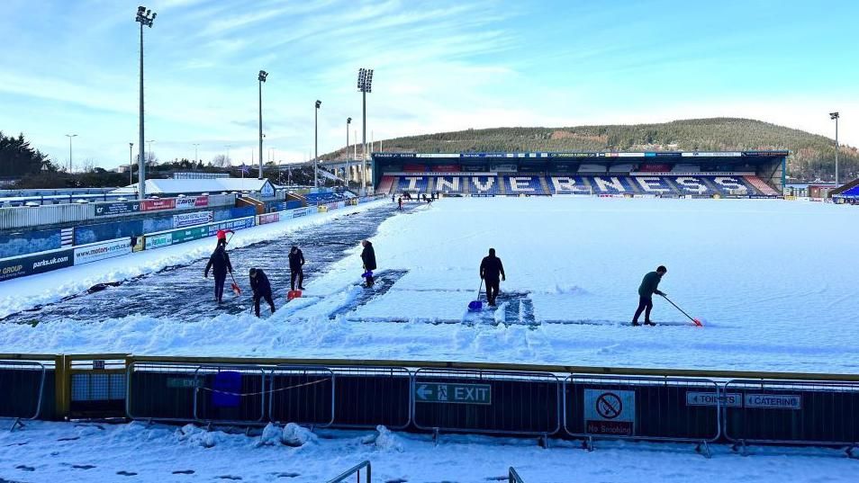 Clearing snow from ICTFC pitch on Friday