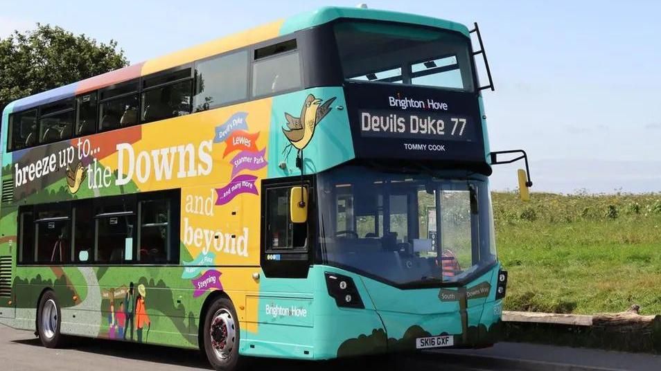 A multi-coloured Brighton & Hove double decker bus