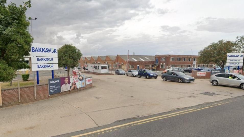 A Google photo of the Bakkavor entrance in Spalding, with signs both sides of an entrance to the site with several cars queuing to come out