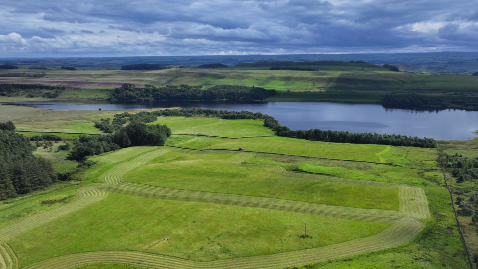 An aerial image of the Greenlee Loug National Nature Reserve with Hadrians Wall behind 