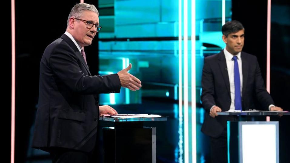 Labour Party leader Keir Starmer (L) and Prime Minister Rishi Sunak speak on stage during the first head-to-head debate of the General Election on June 4, 2024 in Salford 