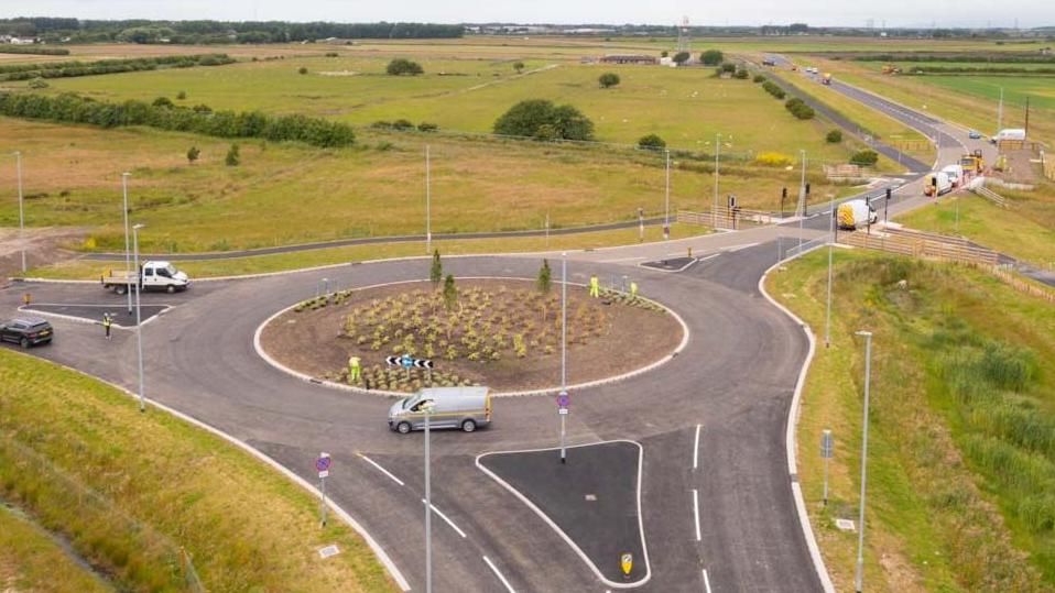 Ariel view of work vans on a roundabout on the new road