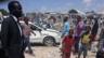 A photo showing the aftermath of the blast, with people standing in front of rubble