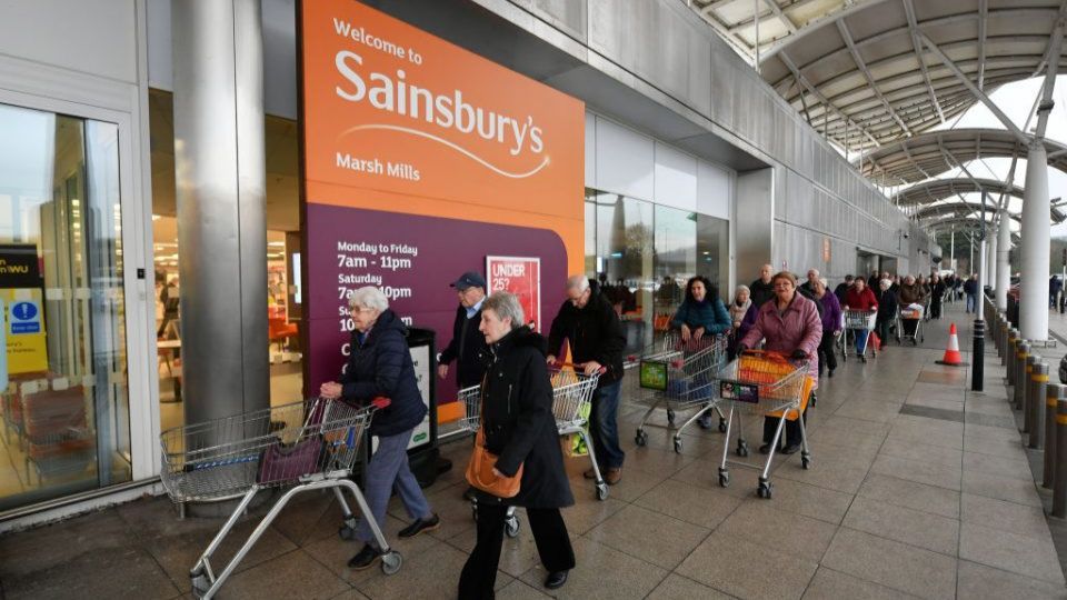 Customers queuing outside Sainsburys.