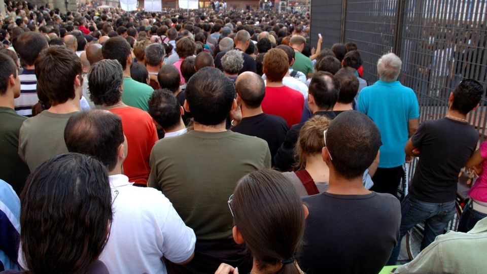 Grupo de gente fotografada por trás