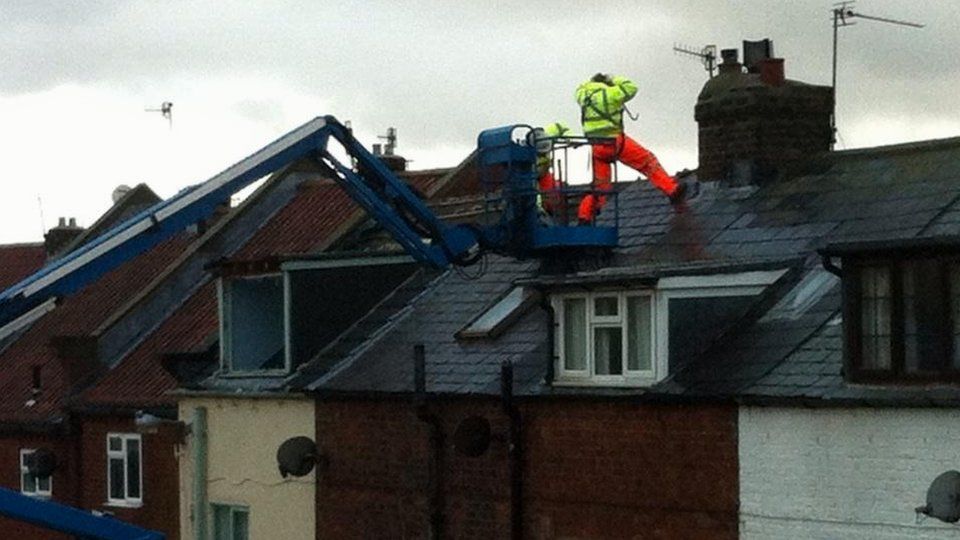 Contractors on the roof of the row of houses in Whitby