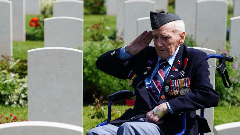 A veteran salutes a grave