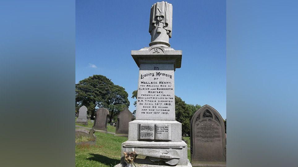 Wallace Hartley's grave featuring a violin and music book who was continued playing as the Titanic sank