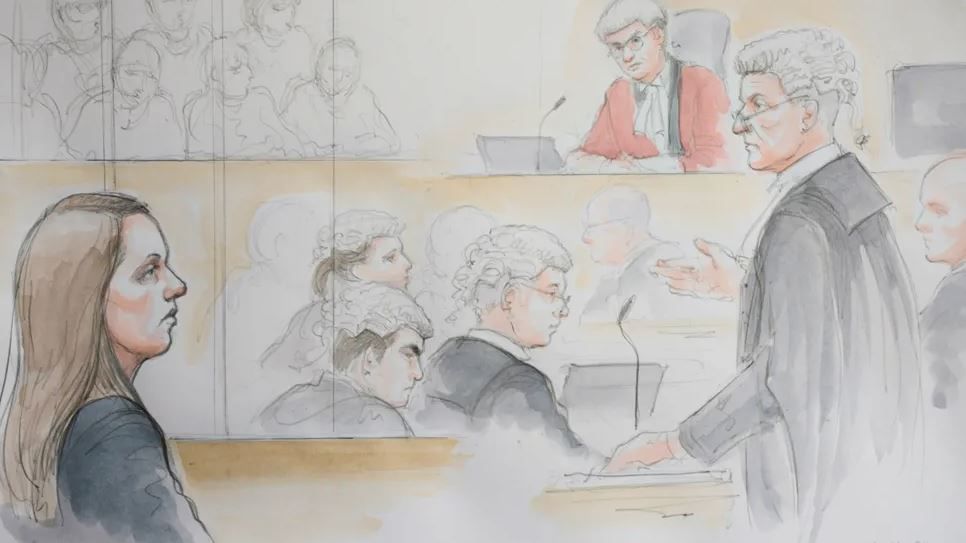 A court sketch of Lucy Letby sat in the dock wearing a black jacket, while a glasses-wearing barrister in a white wig and black gown addresses the court and other legal staff listen to proceedings