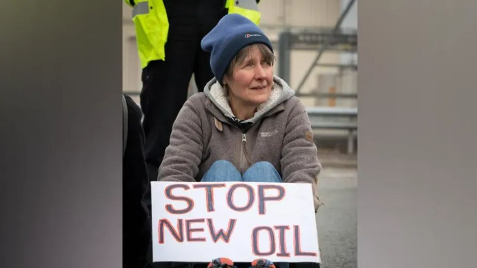 Dr Sarah Benn at the protest, holding a 'stop new oil' sign