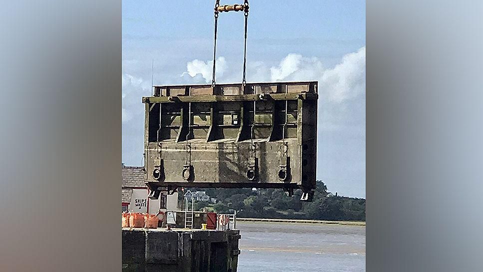 Broken sea gate being lifted from the sea for repairs