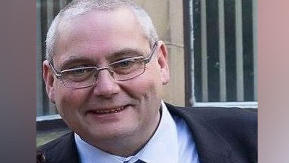 Close up image of a smiling David Daintree wearing a suit