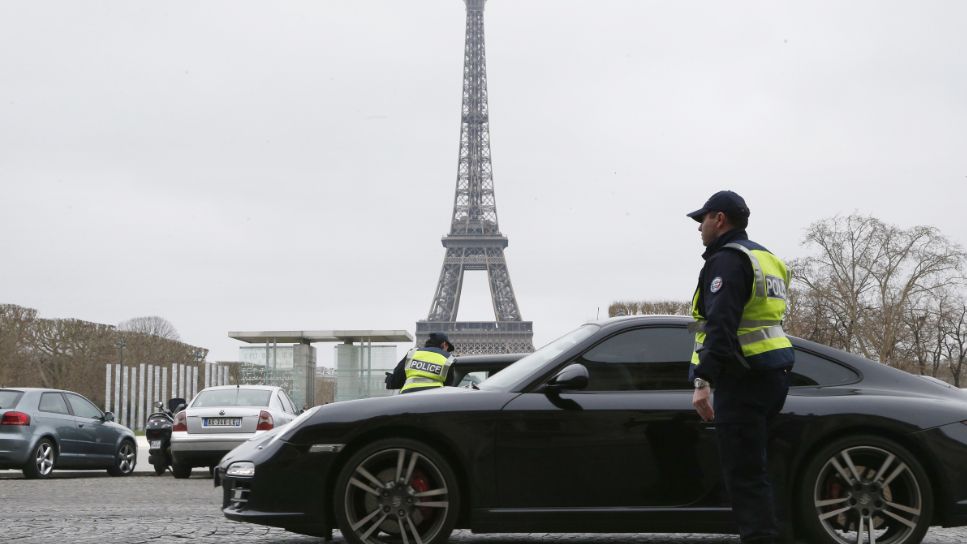 Police officers control cars in front of the Eiffel Tower, in Paris, on March 17, 2014